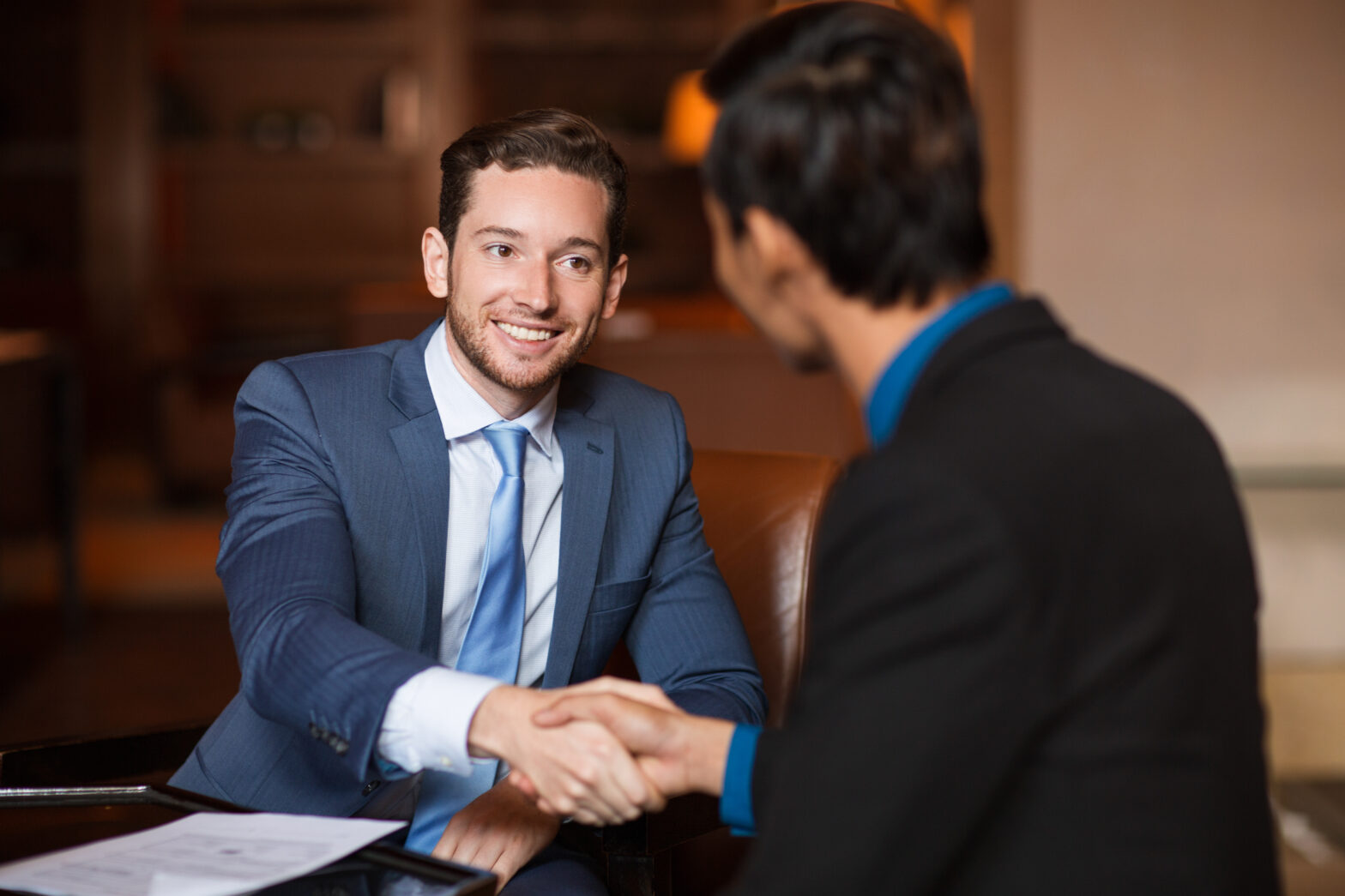Marketing agency owner and client smiling and shaking hands